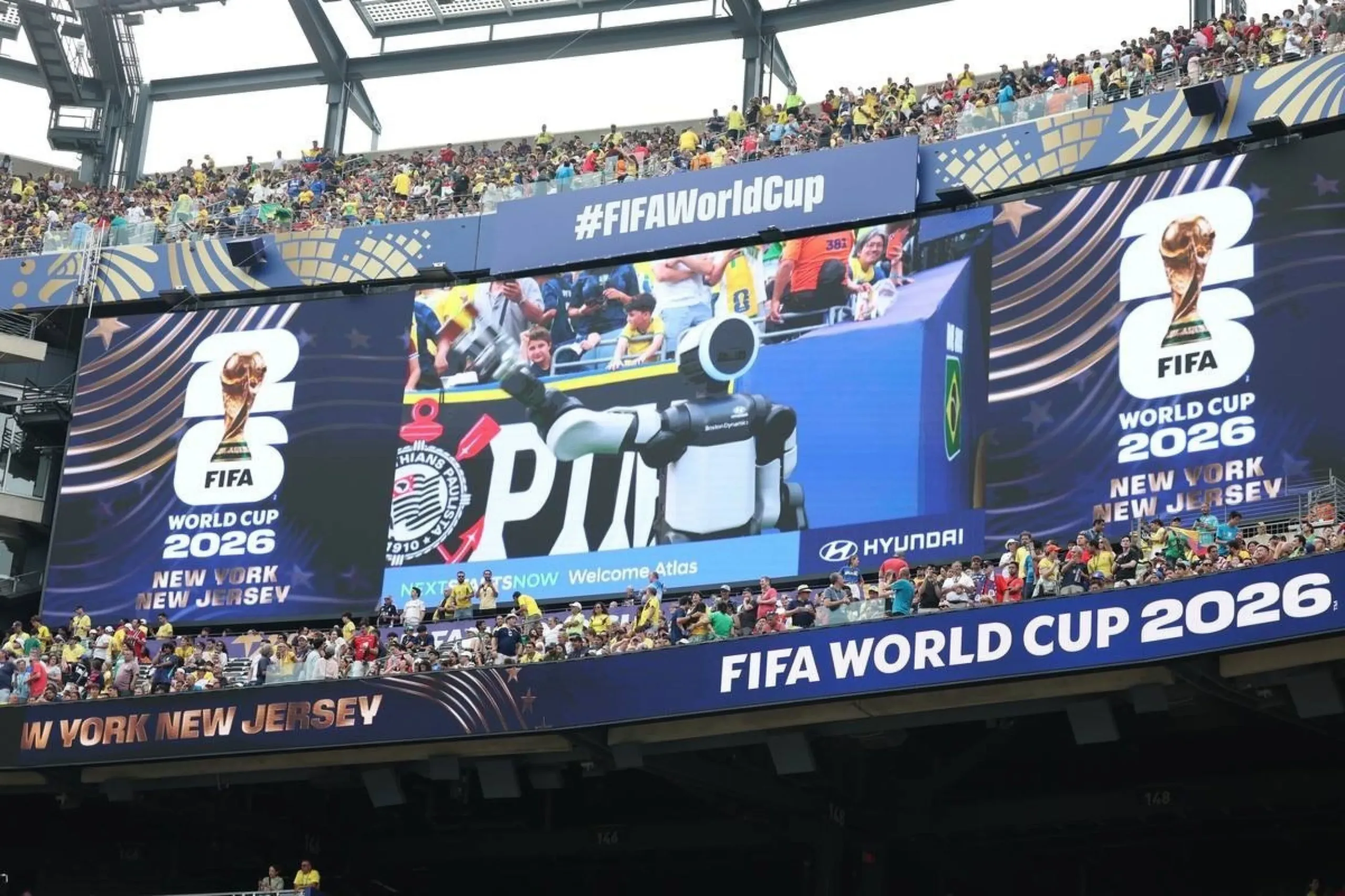 Pantalla gigante del estadio muestra al robot Atlas con el mensaje de bienvenida y el logo de Hyundai