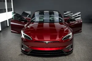Tesla Model S Plaid Signature Edition #001 rojo con las cuatro puertas abiertas en un taller, vista frontal