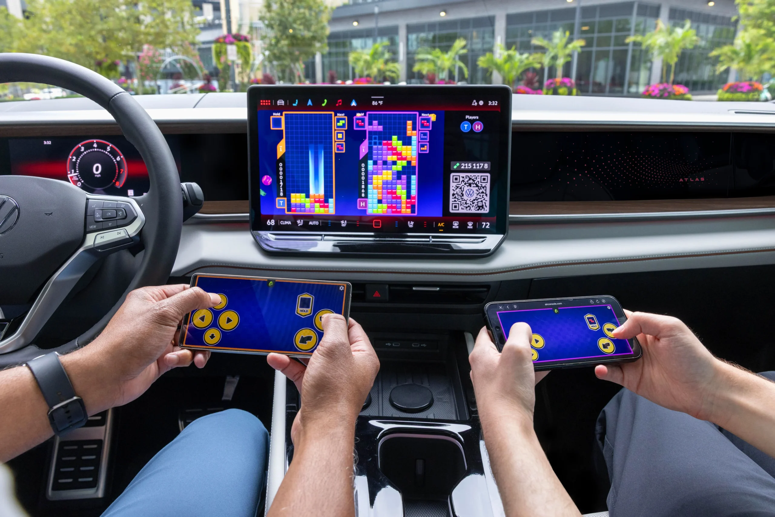 Volkswagen AirConsole con Tetris en la pantalla central y dos ocupantes que usan sus smartphones como mandos
