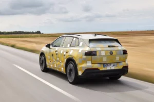 Vista trasera de tres cuartos del prototipo del ID. Tiguan camuflado en una carretera entre campos secos