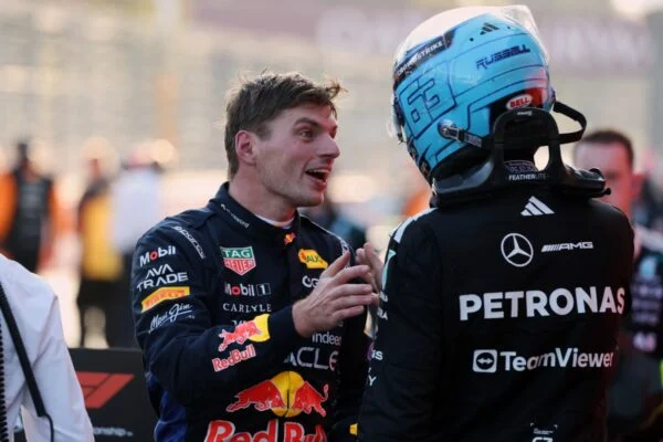 Max Verstappen conversa con George Russell, que aún lleva el casco puesto, después de la carrera