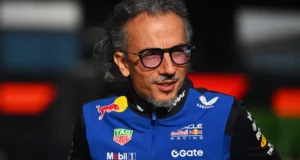 Laurent Mekies, jefe de Red Bull, sonríe con gafas oscuras y la chaqueta azul del equipo en el paddock