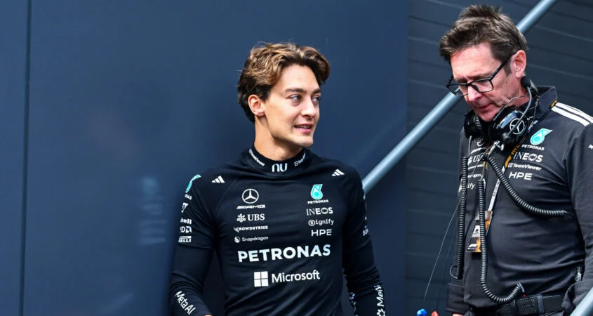 George Russell, con la ropa de Mercedes, conversa con un ingeniero del equipo en el paddock de Bakú