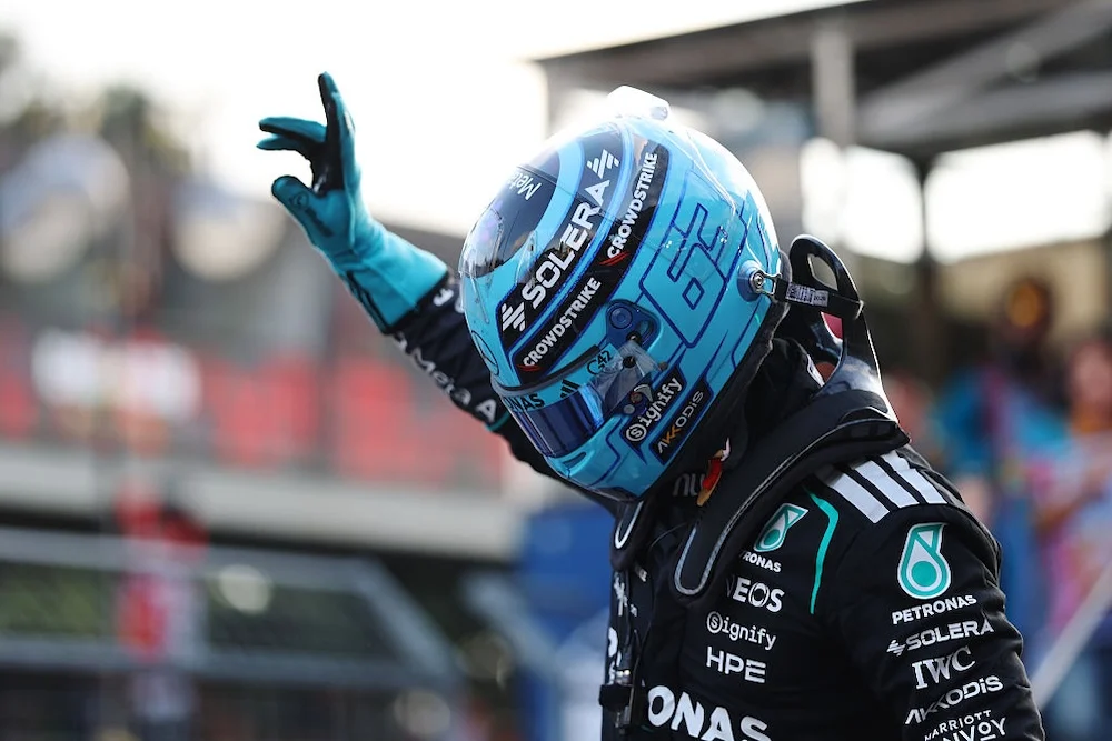 George Russell levanta la mano con el casco puesto tras conseguir la pole del GP de Azerbaiyán