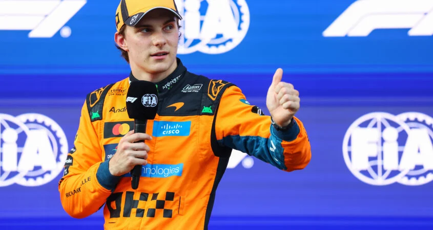 Oscar Piastri, con el buzo naranja de McLaren, levanta el pulgar ante un micrófono en Bakú