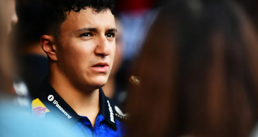Isack Hadjar, con el polo azul de Red Bull, observa concentrado en el paddock de Bakú