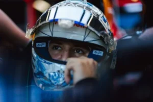 Piloto con casco blanco y azul concentrado dentro de su monoplaza antes de salir a pista en Bakú