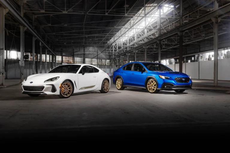 Subaru WRX GD25 azul con llantas doradas junto al BRZ ZC15 blanco con llantas bronce en una nave industrial