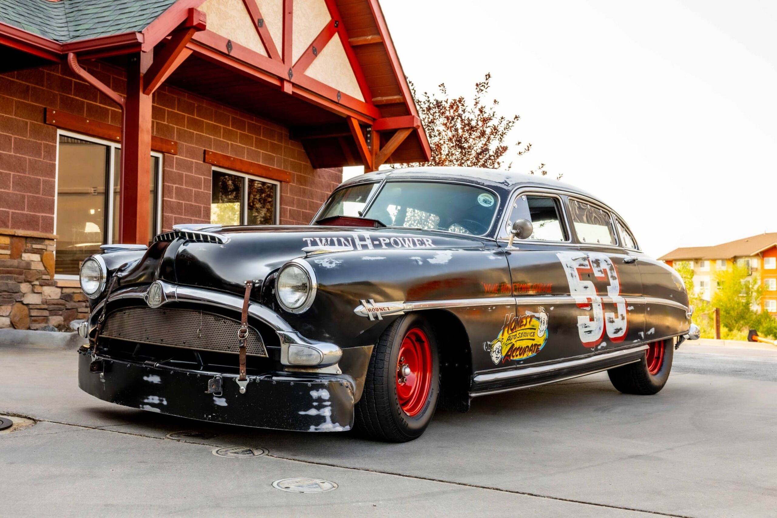 Hudson Hornet negro con ruedas rojas y el número de carrera en la puerta, uno de los autos de la caravana Ruta 66