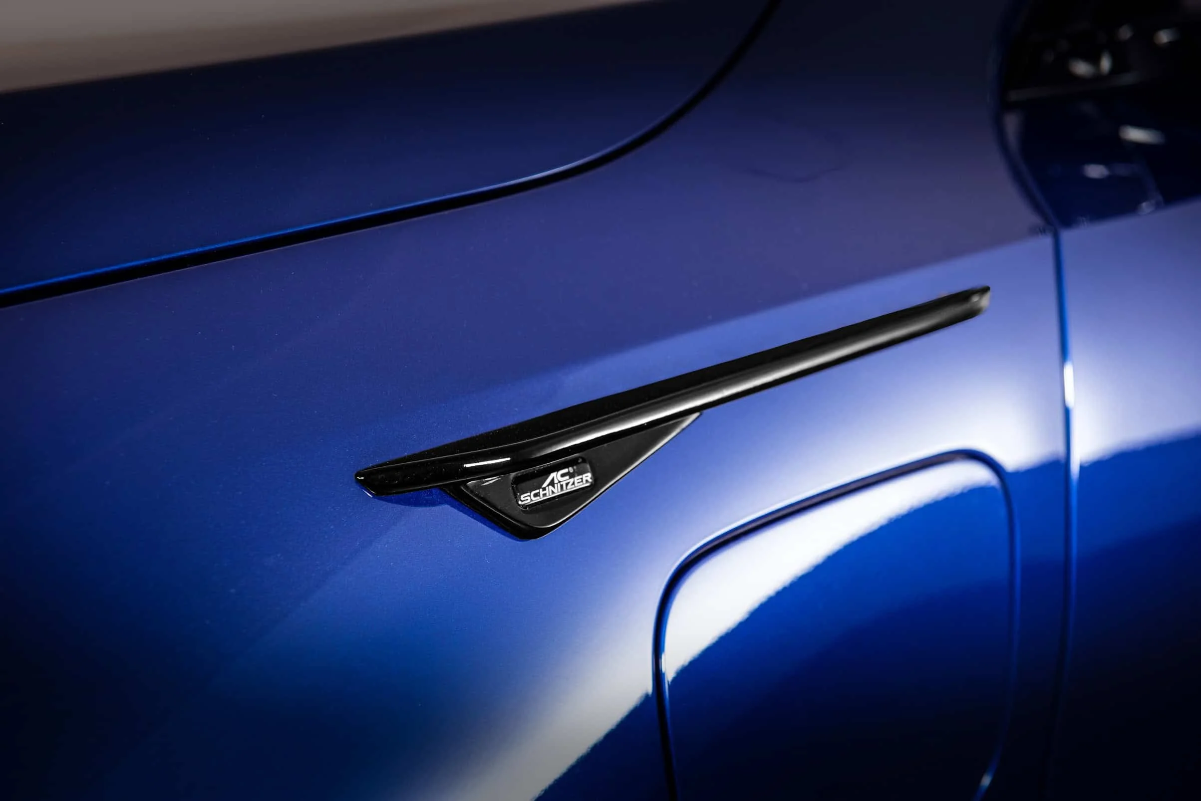 Branquia lateral negra con el logotipo de AC Schnitzer sobre la carrocería azul de un BMW M5