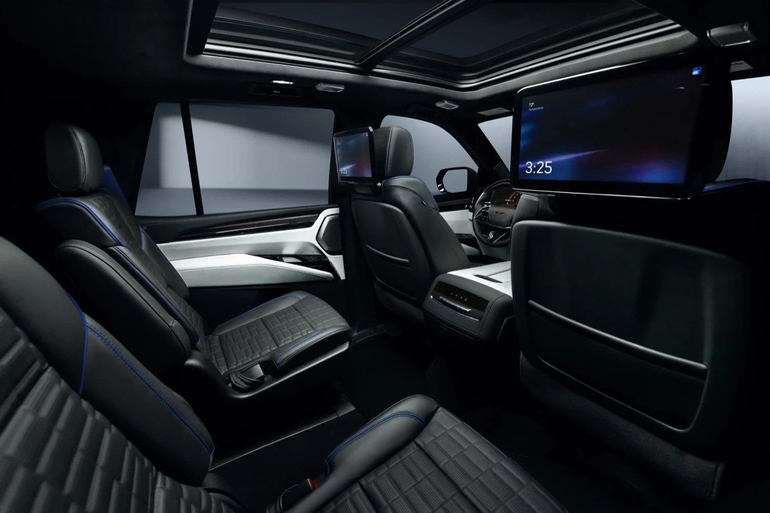 Interior de la Cadillac Escalade-V 125th Anniversary con asientos negros, costuras azules y pantallas traseras