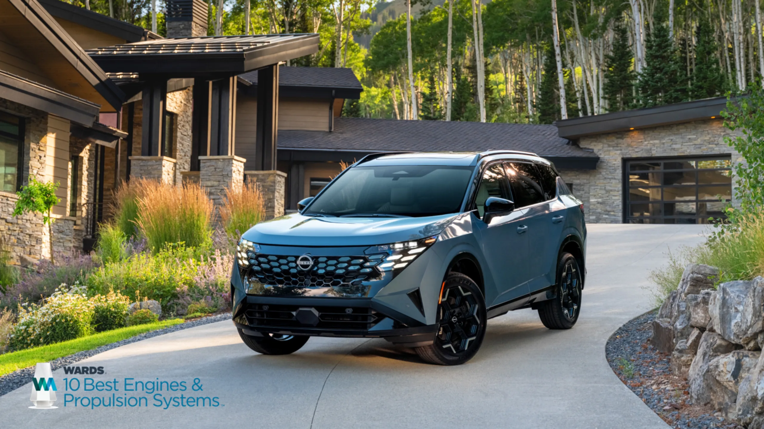 Nissan Rogue Hybrid 2027 azul visto de frente y de costado, estacionado frente a una casa con árboles al fondo