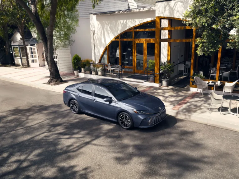 Toyota Camry 2027 gris azulado visto desde arriba en una calle con árboles