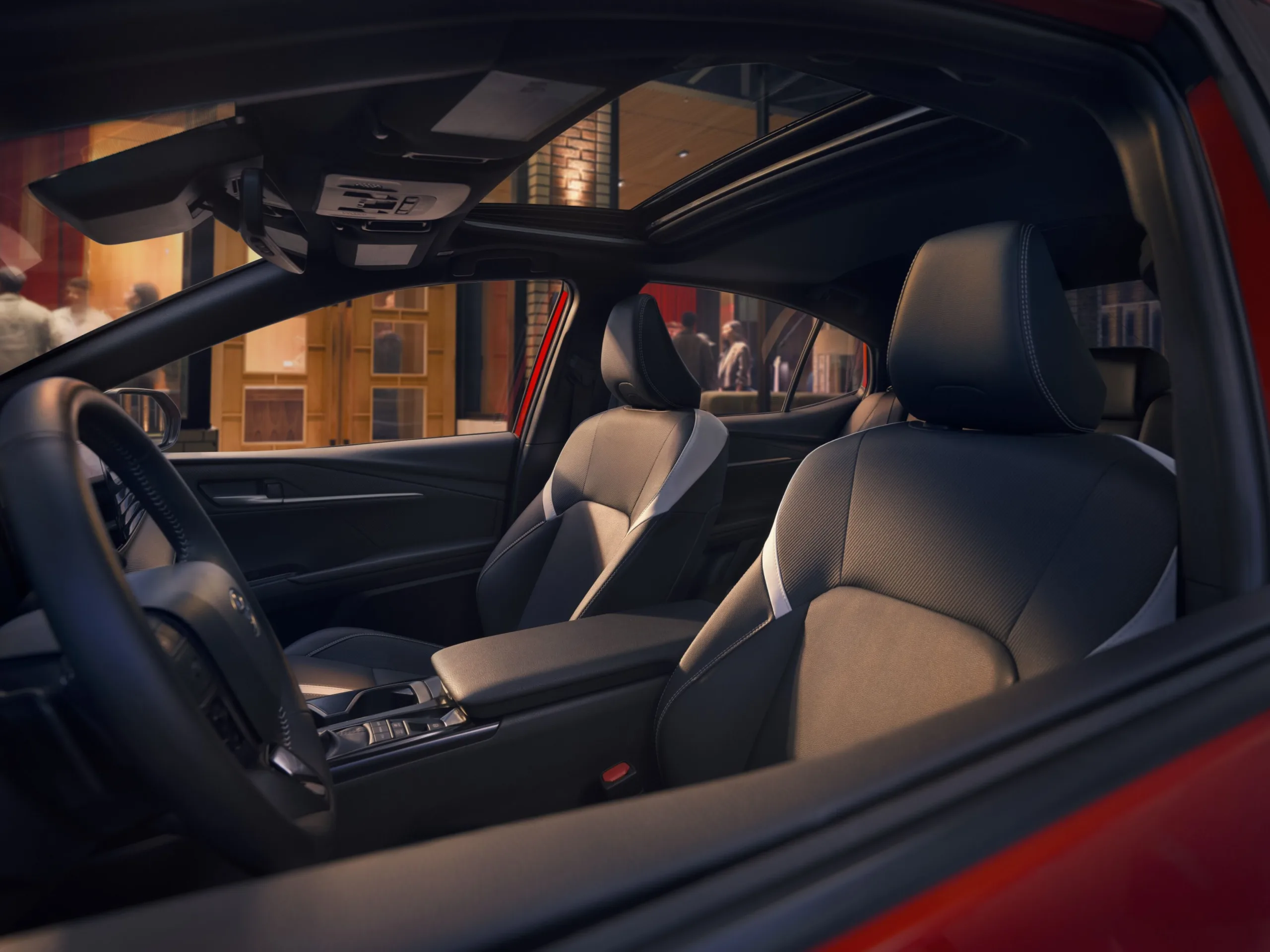 Interior del Toyota Camry Nightshade 2027 con los asientos delanteros en tapicería oscura y el volante