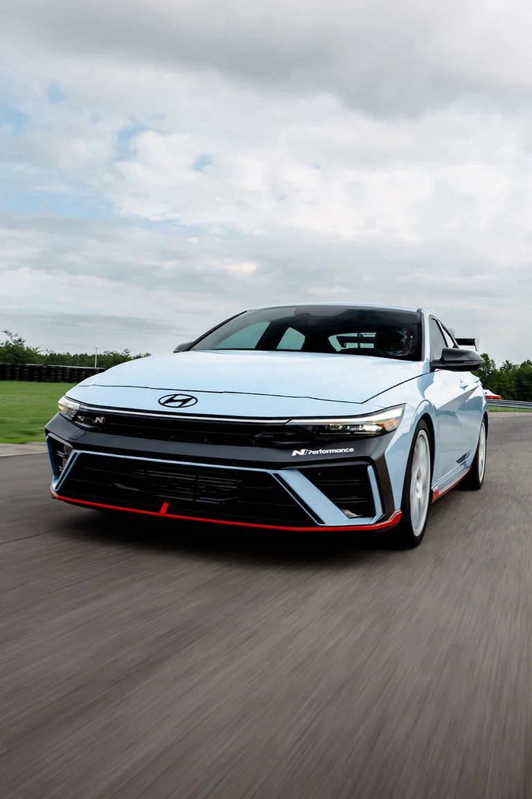 Hyundai Elantra N azul claro visto de frente con el labio delantero N Performance, en una pista