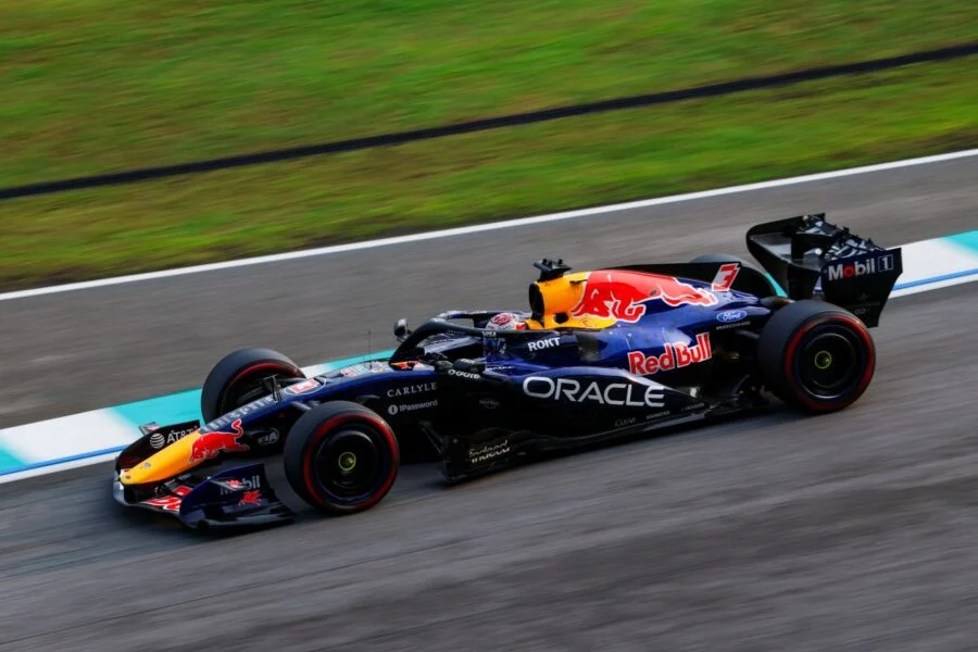 Monoplaza de Red Bull en una curva del circuito de Sepang, sobre el pianito azul y blanco con el pasto al fondo