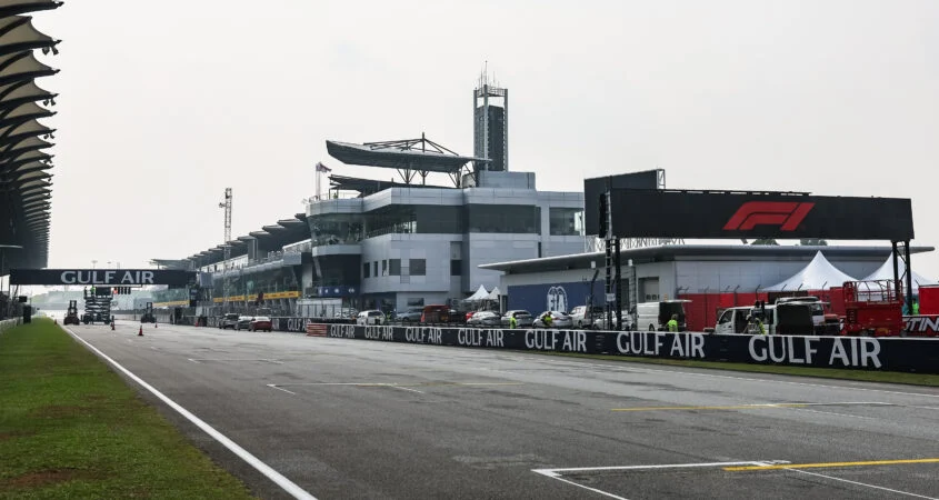 Recta principal y parrilla de Sepang con marcas de salida en el asfalto, frente a los boxes y carteles de Gulf Air