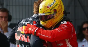 Verstappen abraza a Hamilton, con casco amarillo y buzo rojo de Ferrari, tras la pole en Sepang