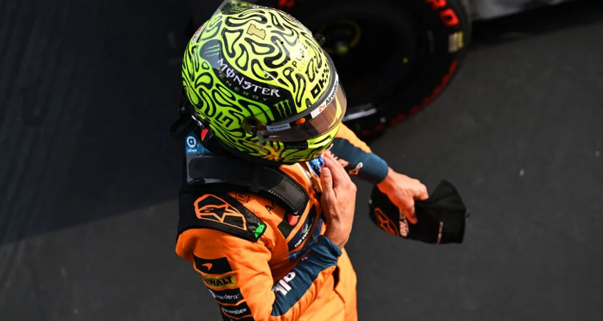 Norris en Sepang tras la clasificación, visto desde arriba con casco verde fosforito y buzo papaya de McLaren