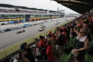 Monoplazas en la recta de Sepang ante aficionados en la tribuna durante el GP de Bahréin 2026