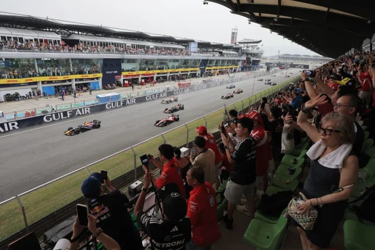 Monoplazas en la recta de Sepang ante aficionados en la tribuna durante el GP de Bahréin 2026
