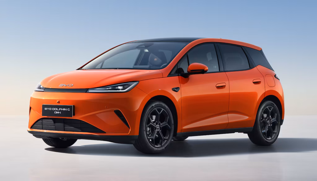 BYD Dolphin G DM-i naranja con techo negro sobre un fondo claro de estudio, vista de tres cuartos delantera