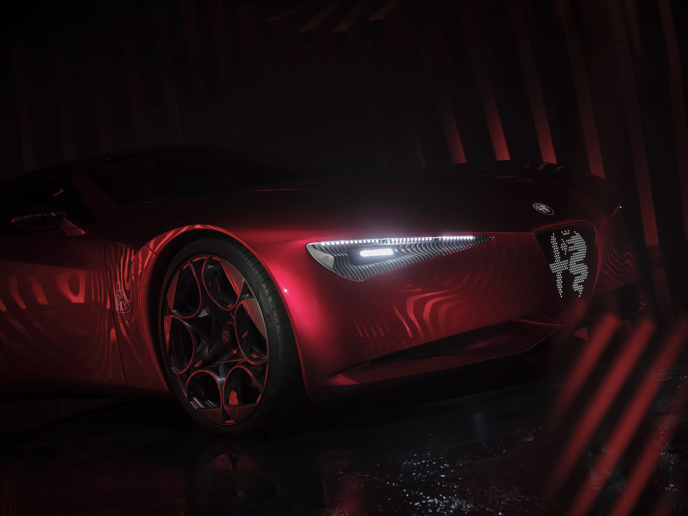 Frente del Alfa Romeo Cuorerosso: faro delgado, Scudetto iluminado y llanta de diseño forjado