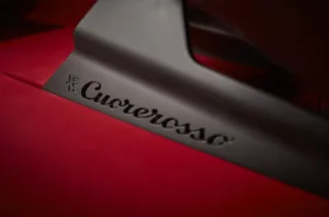 Insignia con el nombre Alfa Romeo Cuorerosso grabado sobre una superficie roja