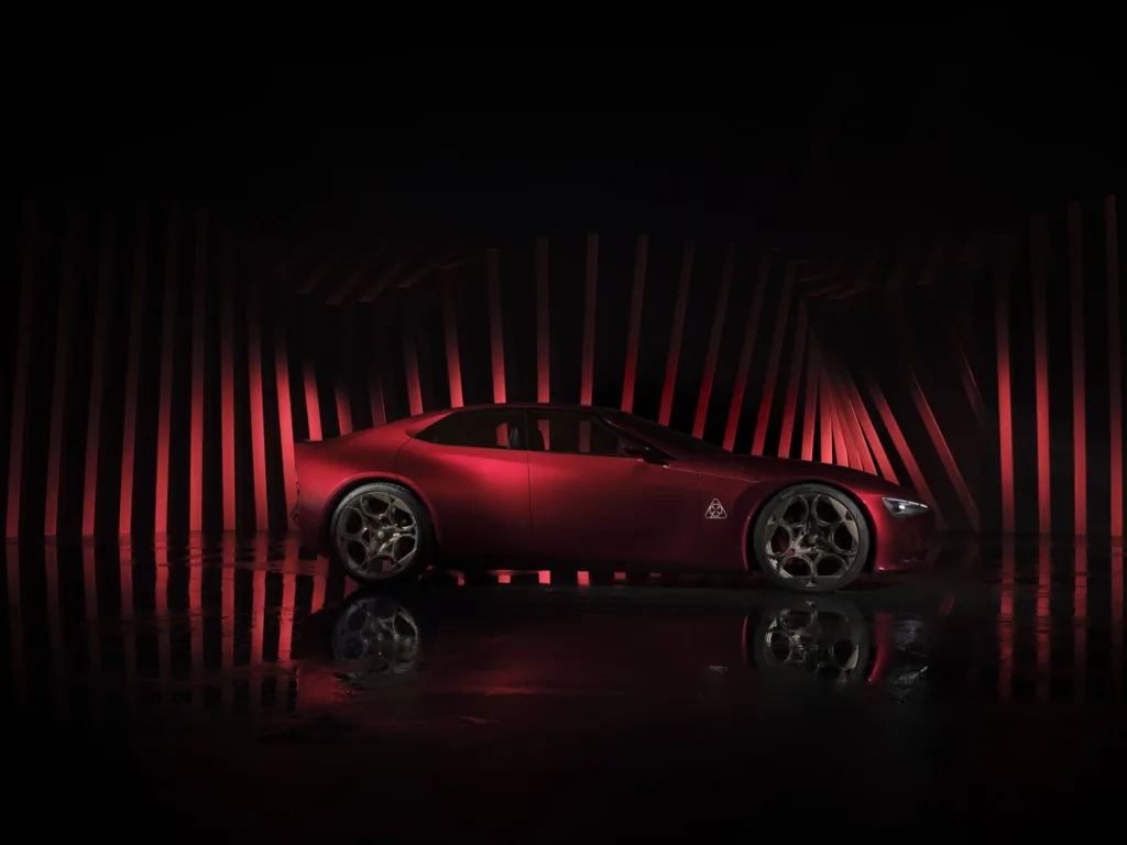 Alfa Romeo Cuorerosso de perfil, un coupé rojo con llantas doradas sobre un fondo de franjas rojas