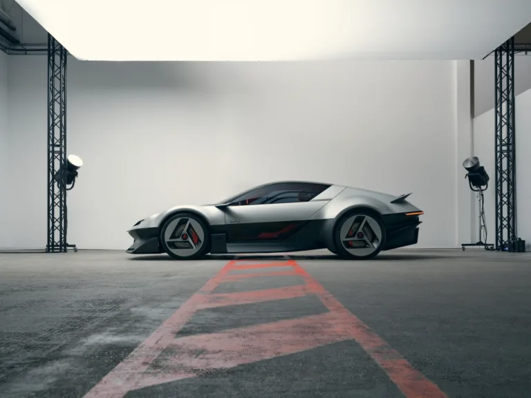 Alpine A310 Vision de perfil en un estudio con focos y una cuadrícula roja en el suelo