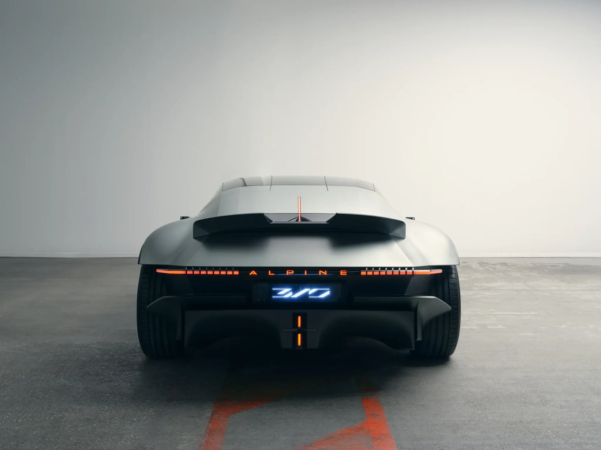 Zaga del Alpine A310 Vision a la altura del suelo, con el alerón, la franja de luces y la parte baja negra