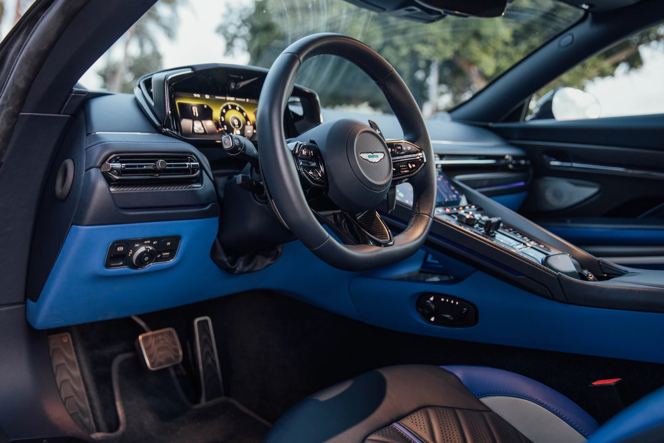 Puesto de conducción del Aston Martin DB12 S con volante, cuadro digital y tablero azul y negro