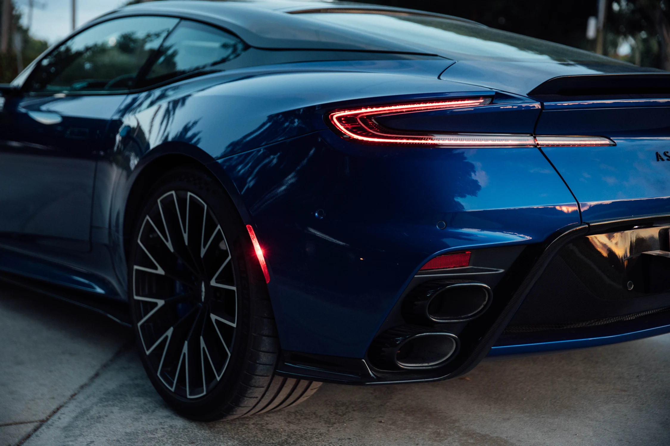 Detalle trasero del Aston Martin DB12 S con la llanta forjada de 21 pulgadas, la luz trasera y las salidas de escape