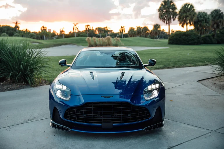 Frente del Aston Martin DB12 S azul con la parrilla grande, el divisor delantero y las aberturas del capó