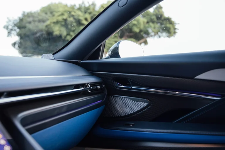 Panel de la puerta y salida de aire del tablero del Aston Martin DB12 S, en azul y negro con luz ambiental