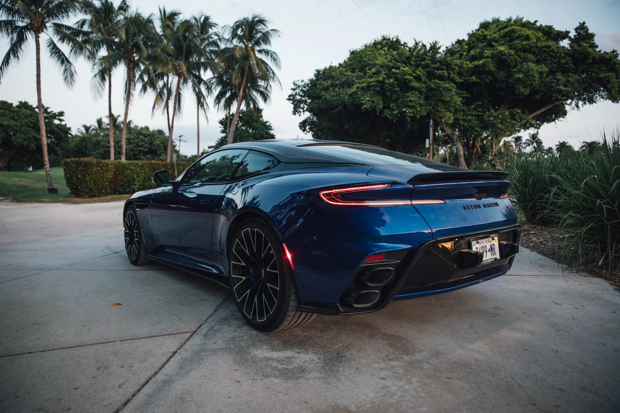 Parte trasera del Aston Martin DB12 S azul con la franja de luces, el alerón fijo y las cuatro salidas de escape