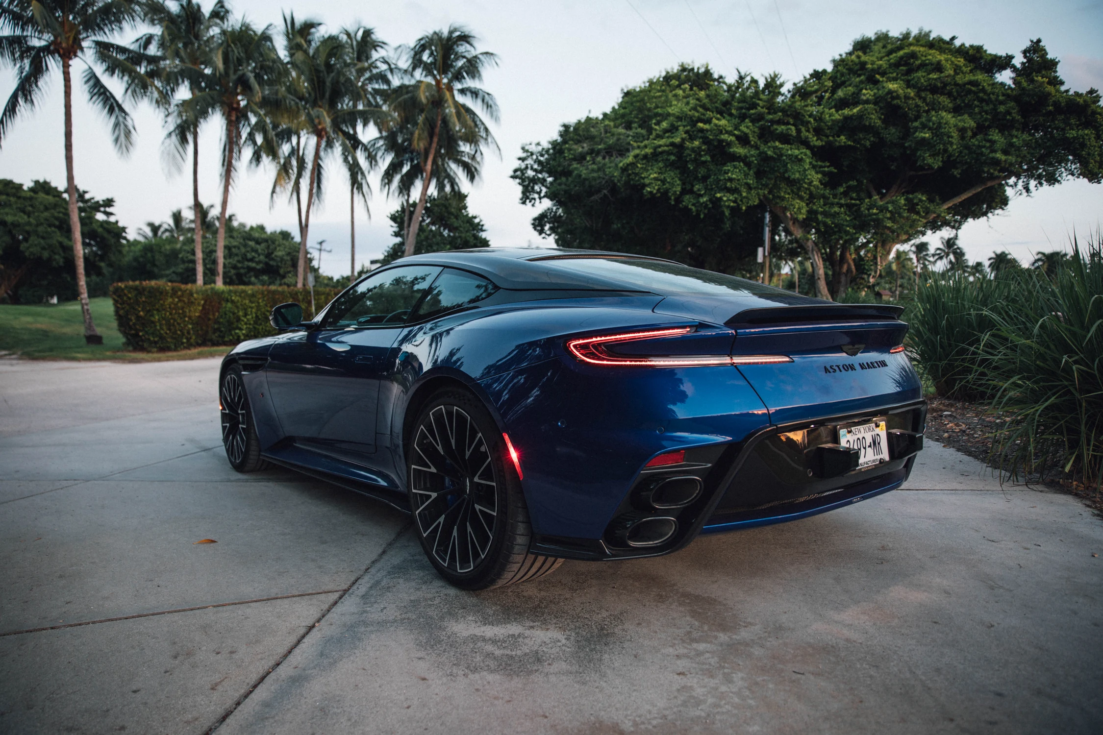 Parte trasera del Aston Martin DB12 S azul con la franja de luces, el alerón fijo y las cuatro salidas de escape