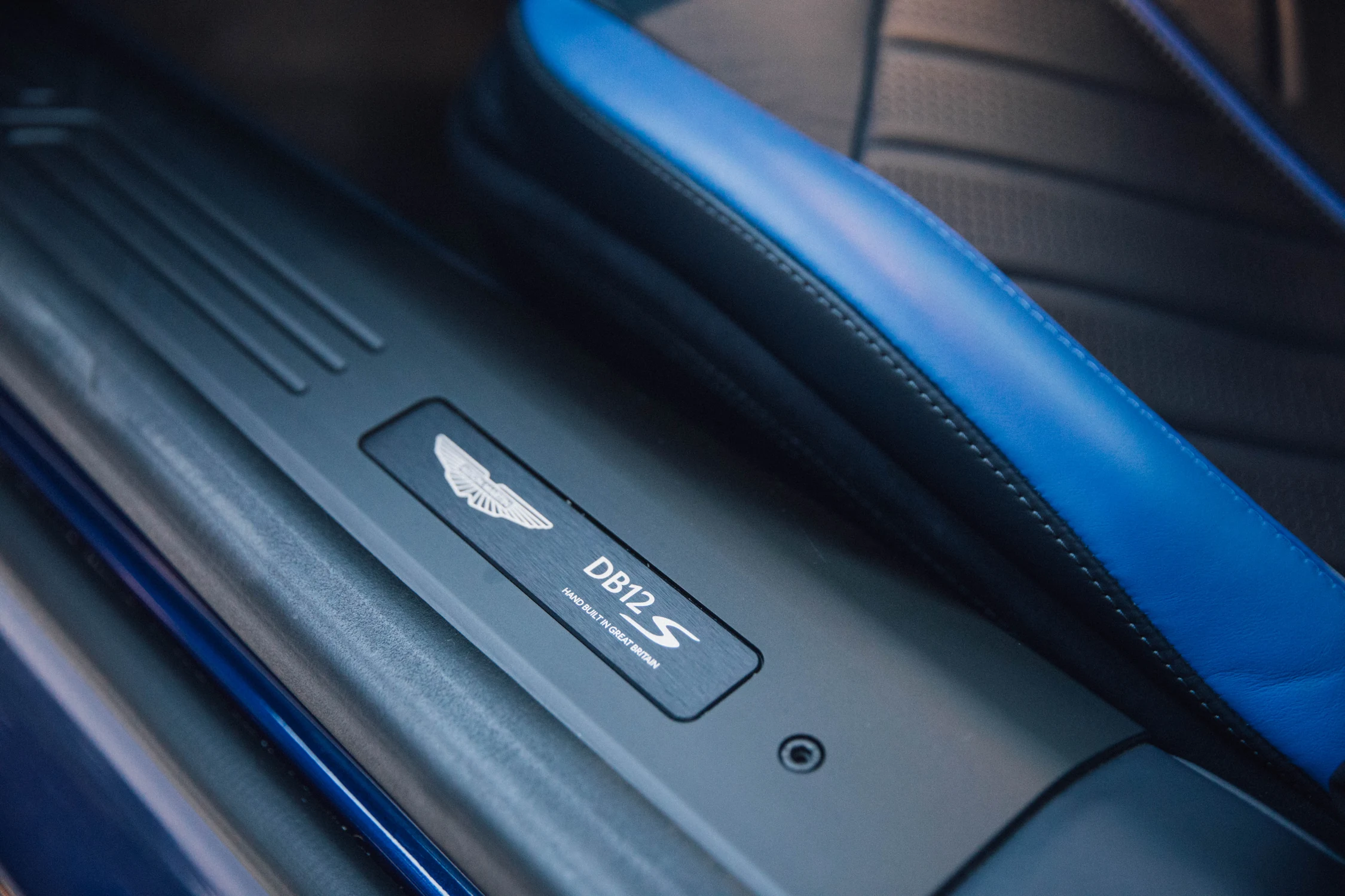 Placa del umbral de la puerta del Aston Martin DB12 S con el logo de alas de Aston Martin