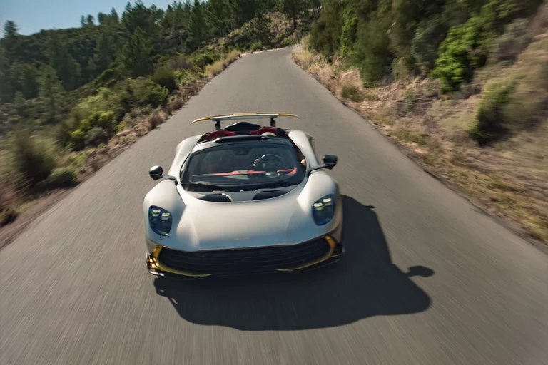 Aston Martin Valhalla Spider de frente, visto desde arriba en una carretera de montaña, con el alerón a la vista