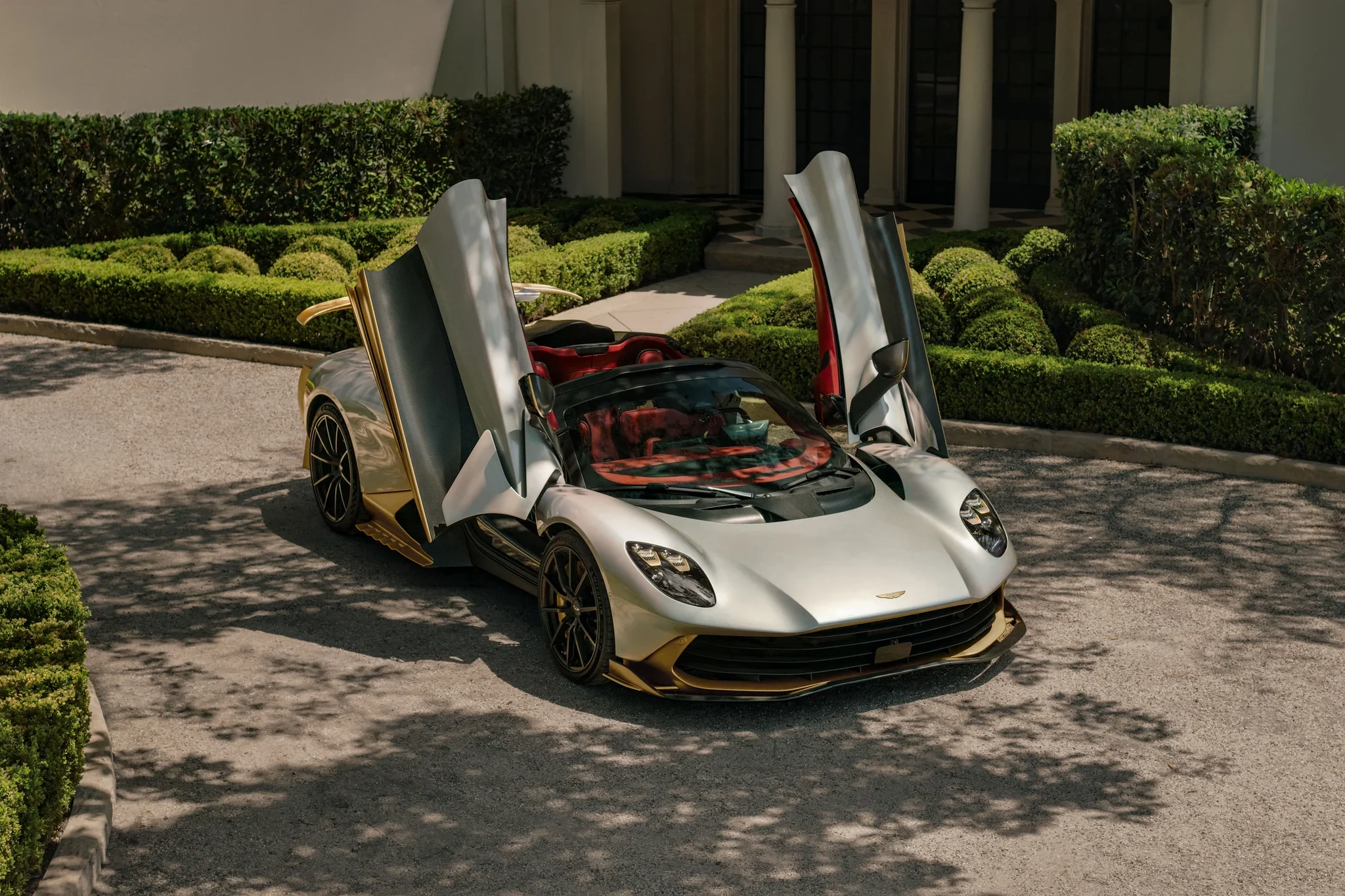 Aston Martin Valhalla Spider con las puertas diedras abiertas, visto desde arriba en la entrada de una casa