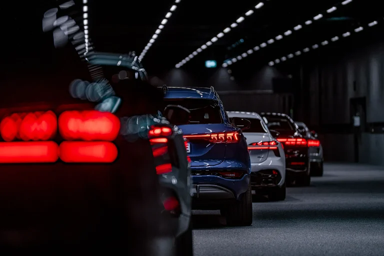 Fila de autos vistos desde atrás con las luces traseras encendidas en un túnel oscuro