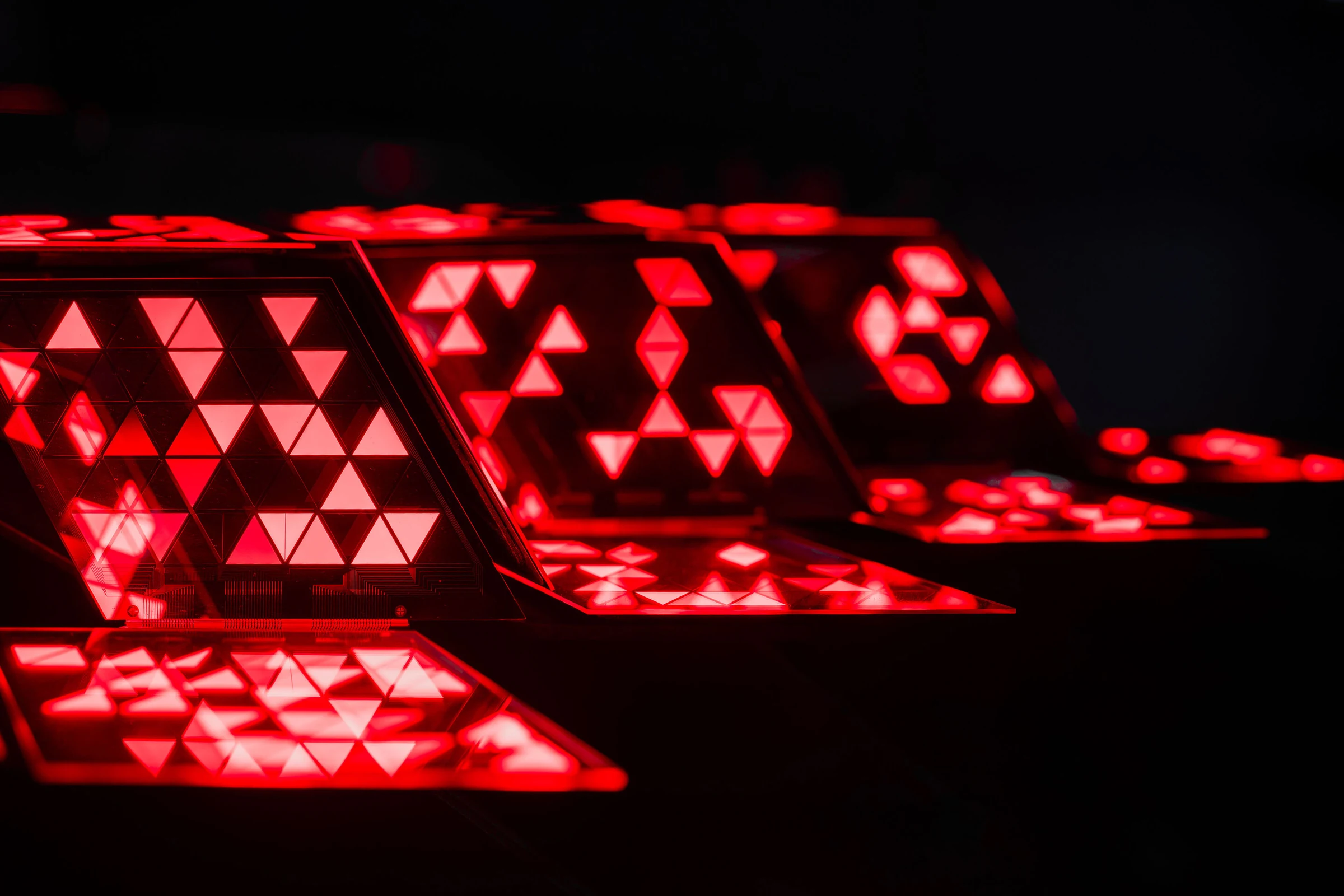 Primer plano de los segmentos triangulares de una luz trasera digital OLED de Audi encendidos en rojo