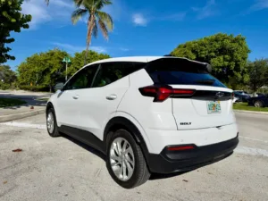 Chevrolet Bolt 2027 visto desde atrás en tres cuartos, con la luneta trasera oscura