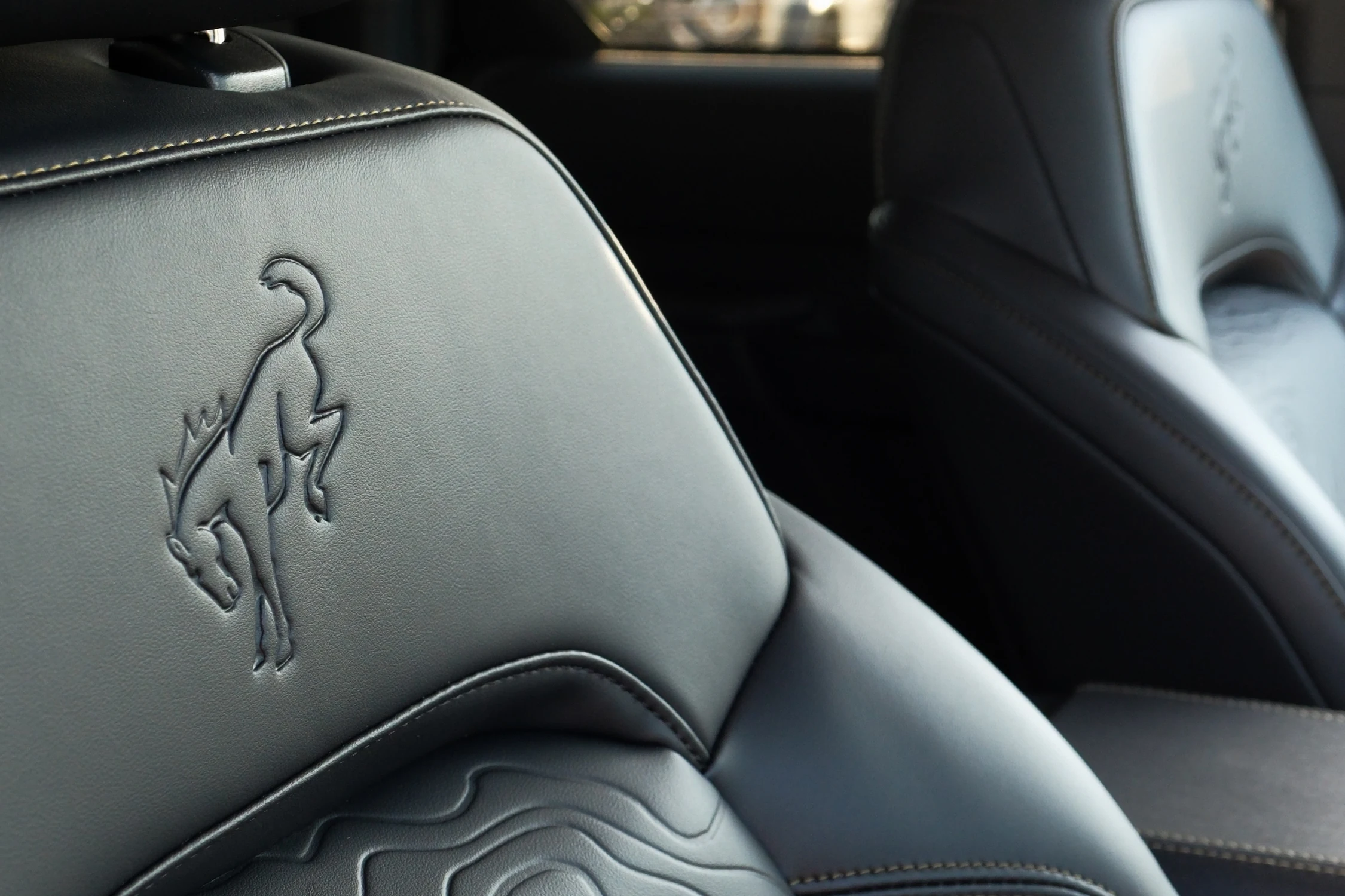 Asiento de vinilo del Ford Bronco 2027 con el caballo del Bronco en el respaldo y un relieve de curvas de nivel