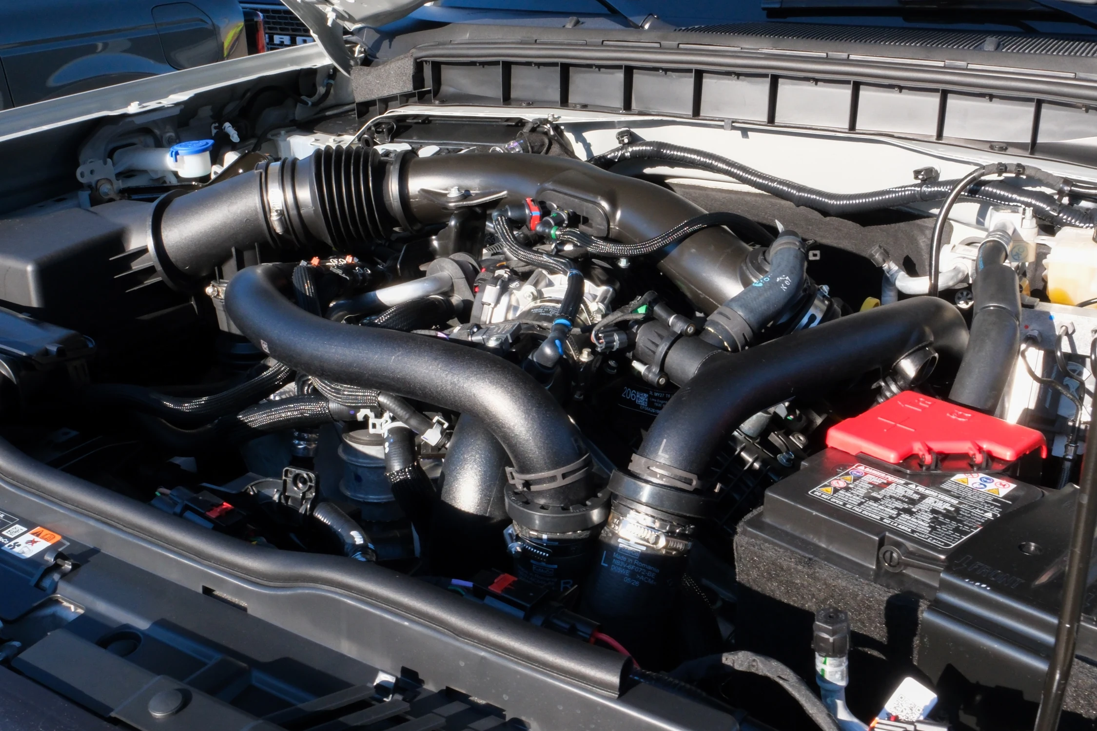 Motor 3.0 EcoBoost V6 biturbo del Ford Bronco 2027 bajo el capó, con sus mangueras y tuberías de admisión