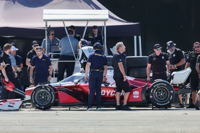 Equipo de mecánicos y técnicos trabajando alrededor del Dallara IR28 en la carpa de boxes de Sebring