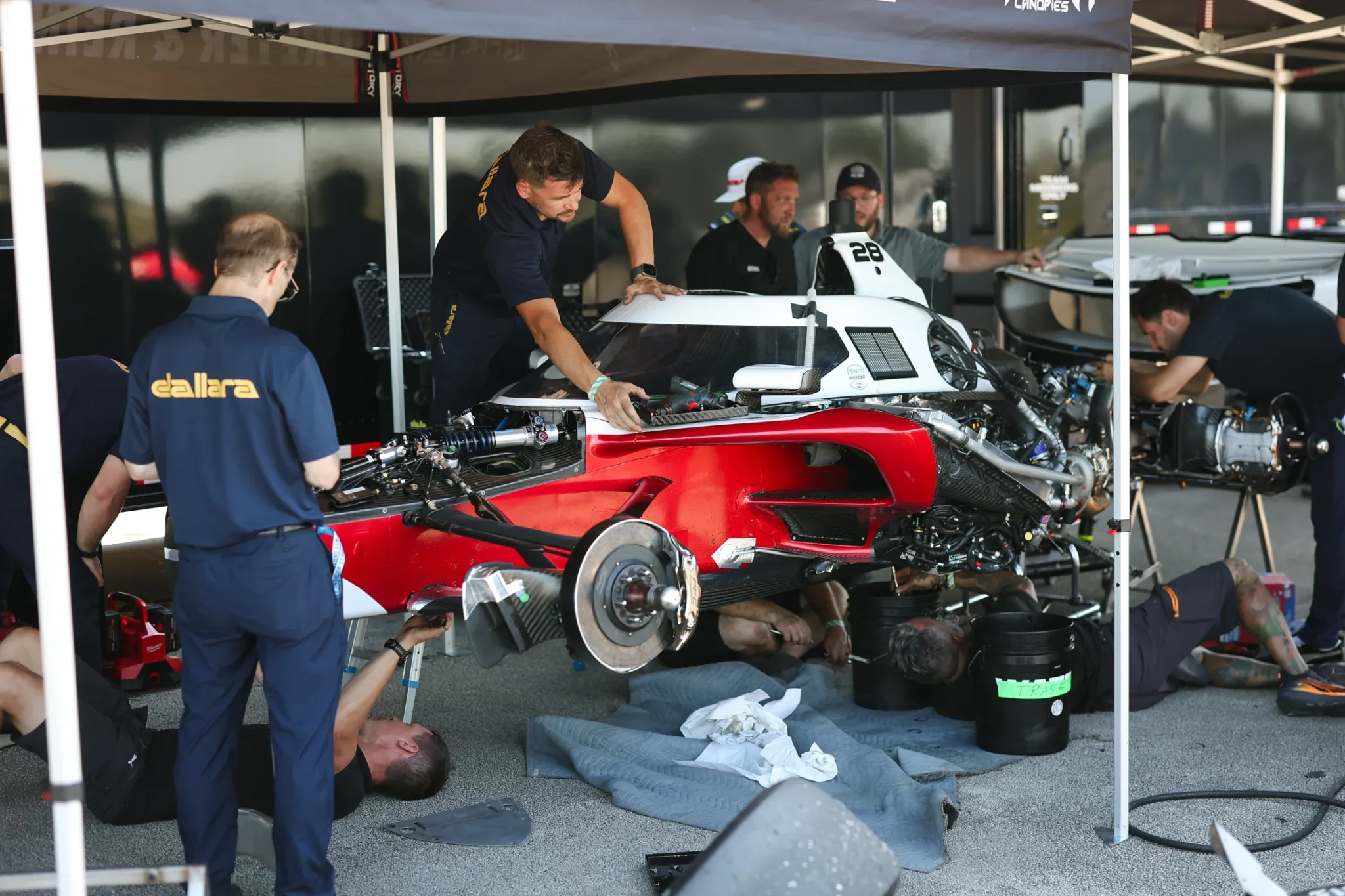 Mecánicos y personal de Dallara trabajando en el Dallara IR28 bajo una carpa en Sebring