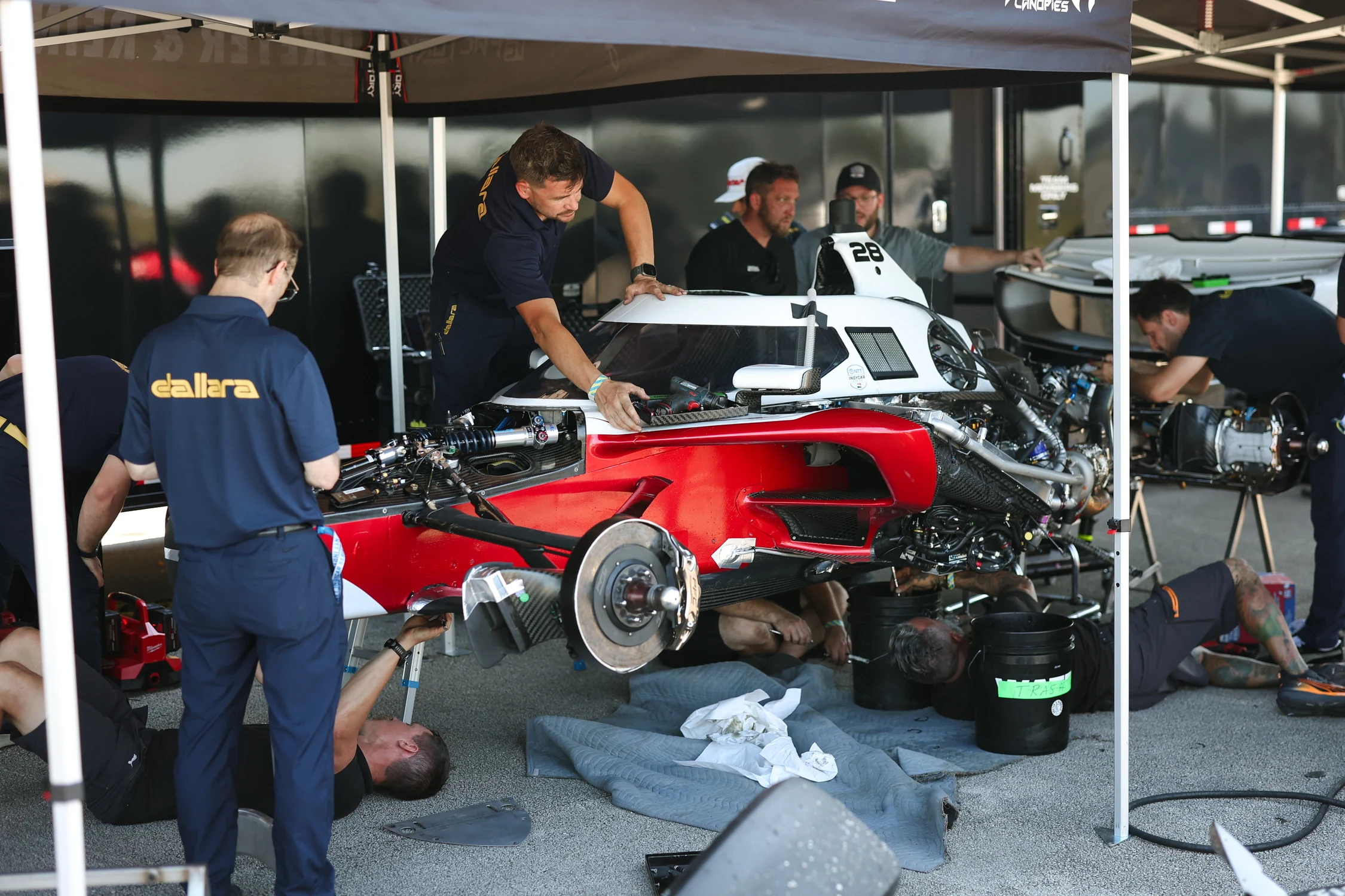 Mecánicos y personal de Dallara trabajando en el Dallara IR28 bajo una carpa en Sebring