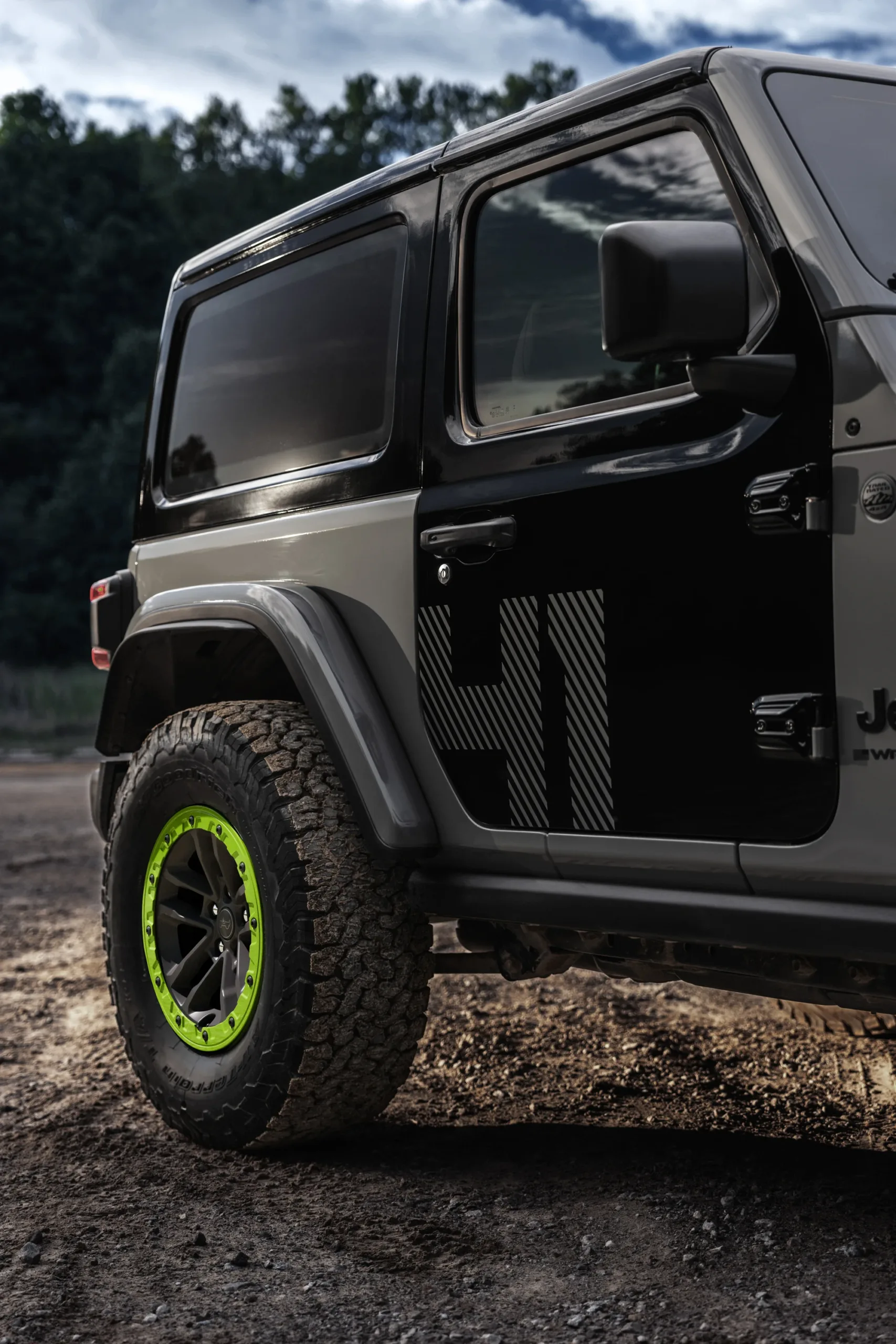 Costado del Jeep Wrangler Switchback con el decal 41 en la puerta negra y la llanta con anillo verde Gecko