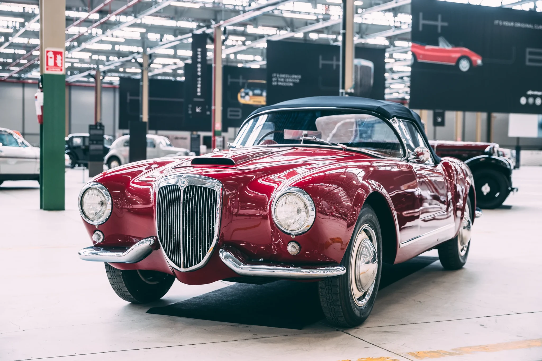 Lancia Aurelia convertible granate de los años cincuenta, expuesto en el Heritage Hub de Turín